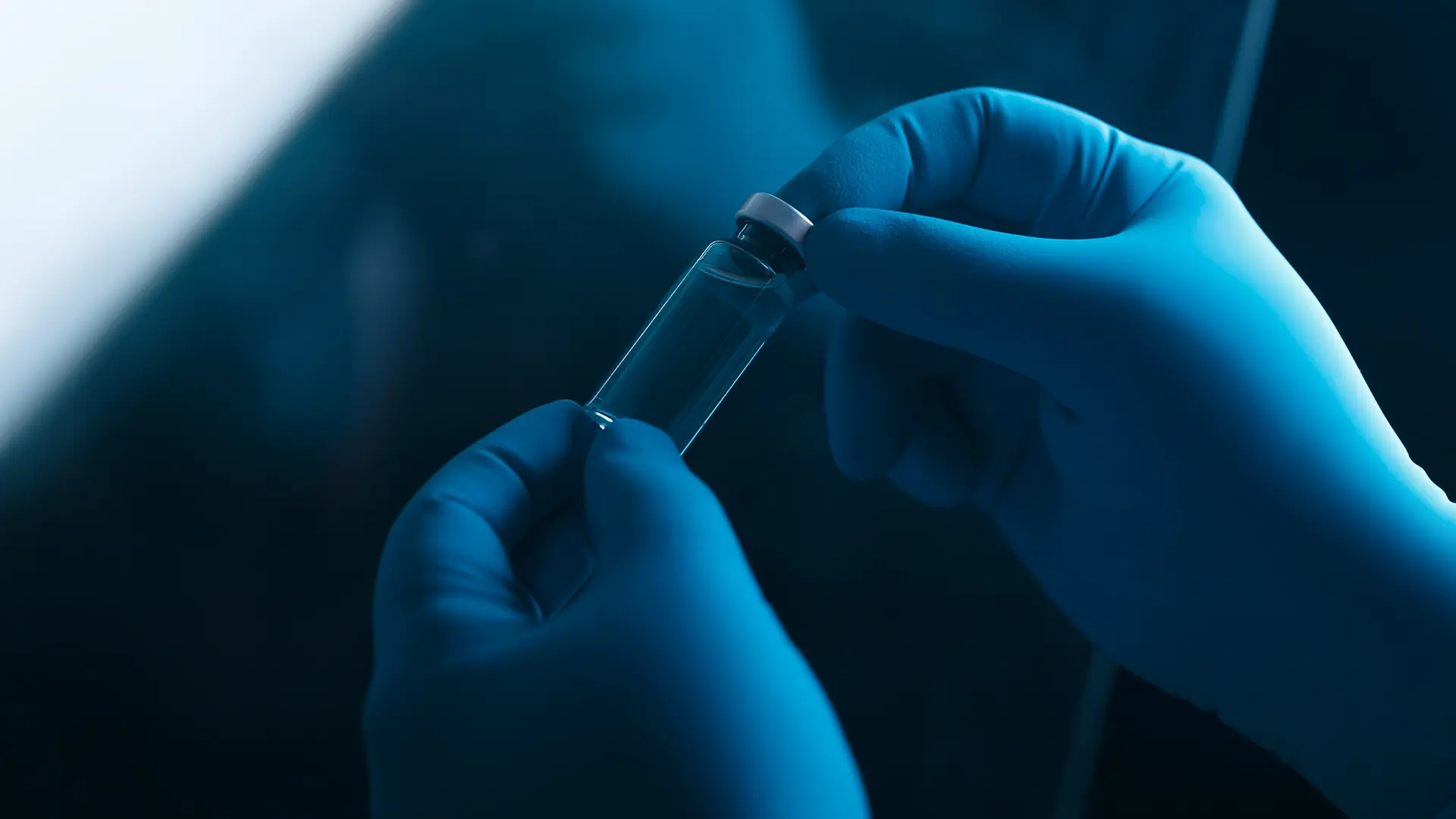 Gloved hands inspecting a sterile vial, representing aseptic handling, sterility assurance, and PUPSIT compliance under EU GMP Annex 1